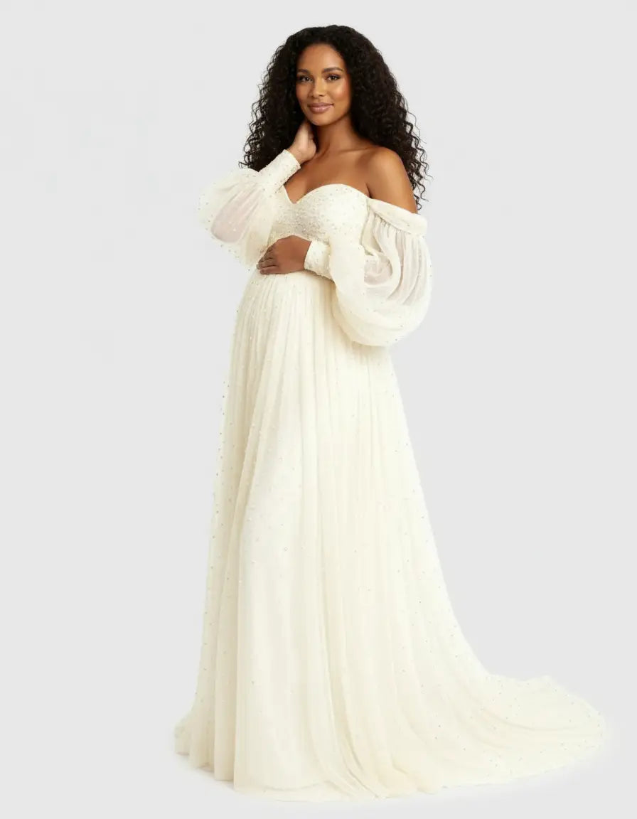 Pregnant woman in an off-shoulder ivory tulle maternity gown with balloon sleeves and a pearl-embellished train.