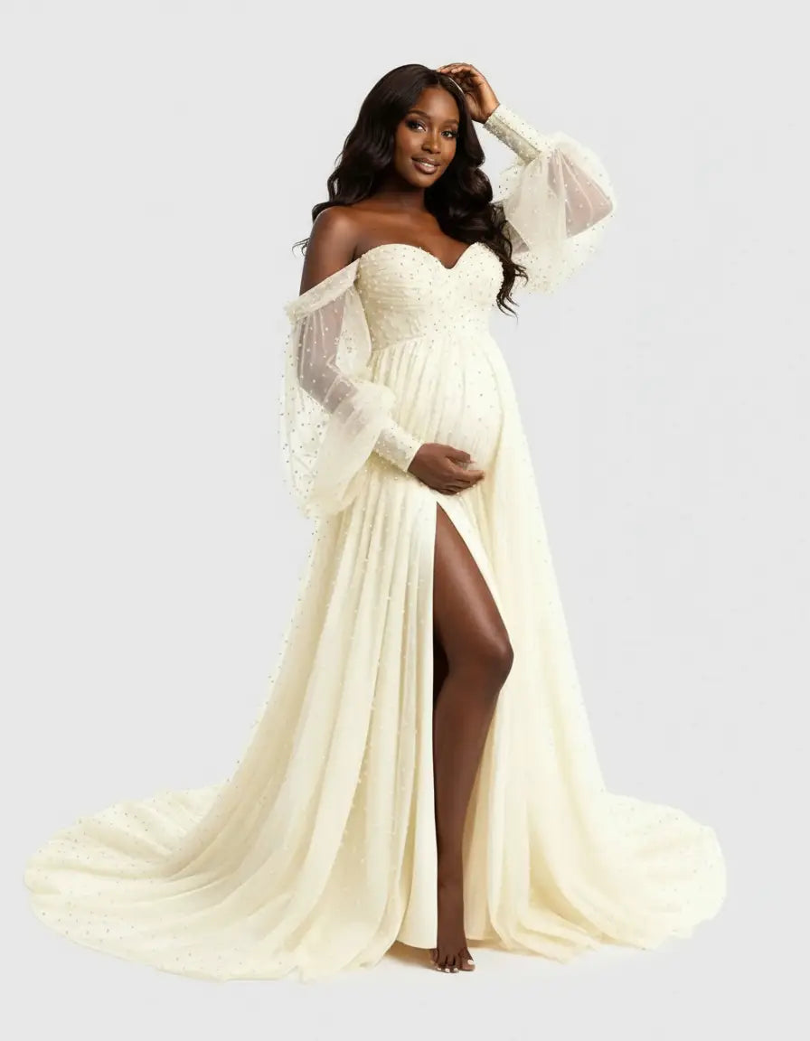 Off-shoulder ivory tulle maternity gown with sheer balloon sleeves, a sweetheart neckline, and a thigh-high slit.
