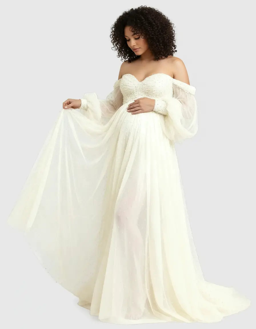 Pregnant woman in an off-shoulder ivory tulle train maternity gown with pearl details.
