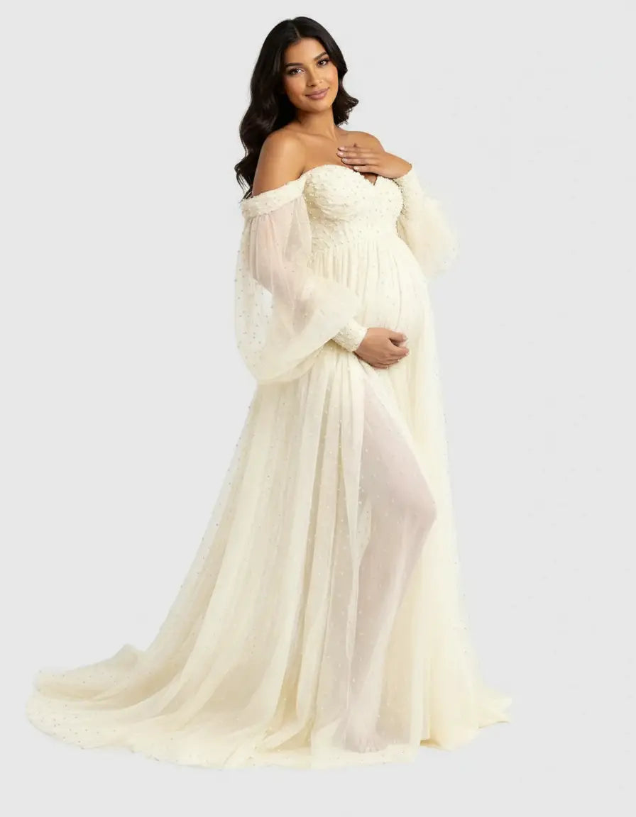 Off-shoulder ivory tulle train maternity gown with long sheer sleeves and delicate embellishments.