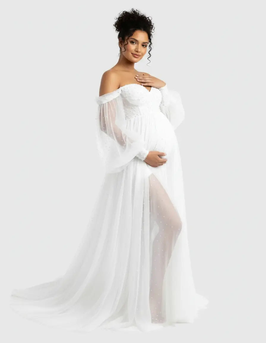 White off-shoulder tulle train maternity gown with sheer sleeves and a thigh-high slit.