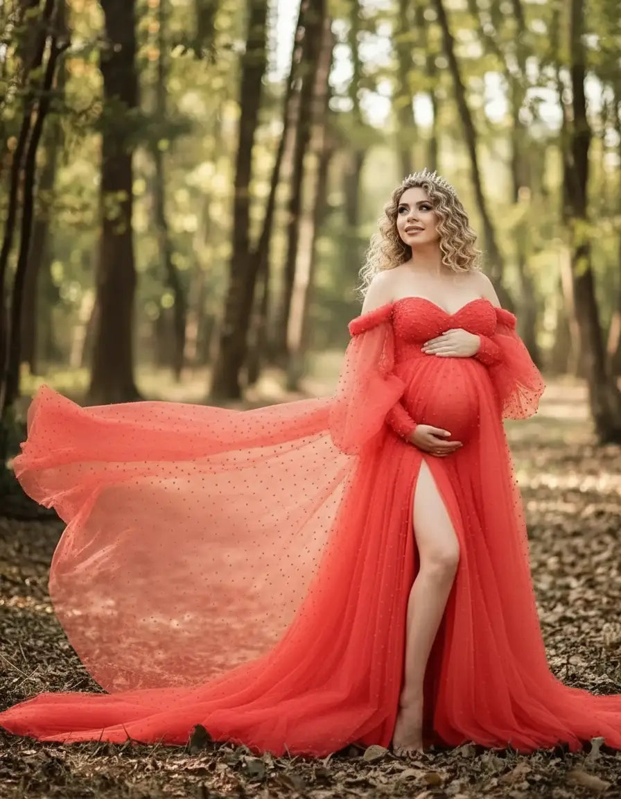 Pregnant woman in a red off-shoulder tulle train maternity gown with a thigh-high slit, posing in a forest.