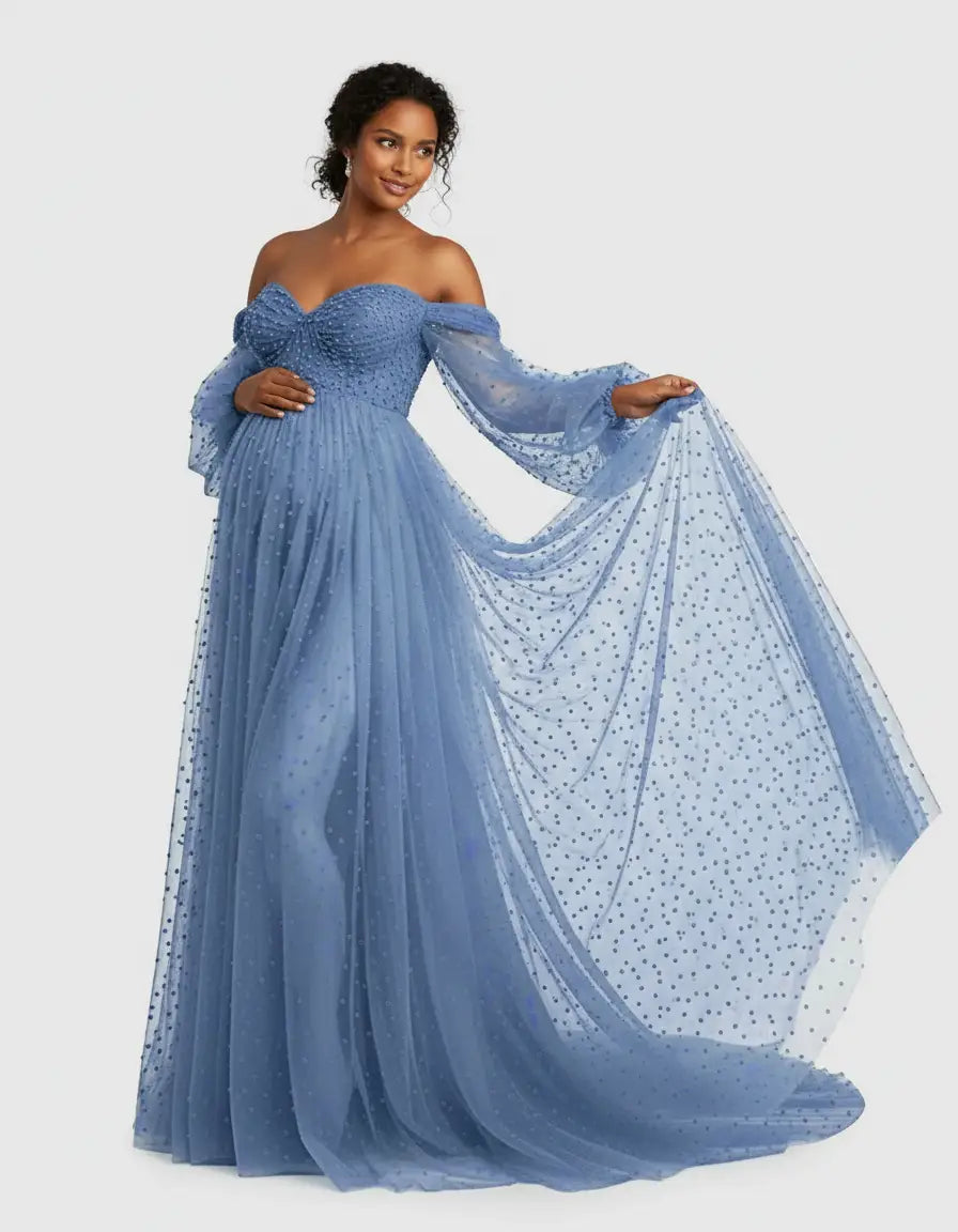 Smiling pregnant woman in a dusty blue off-shoulder tulle gown with polka dots and a flowing train.