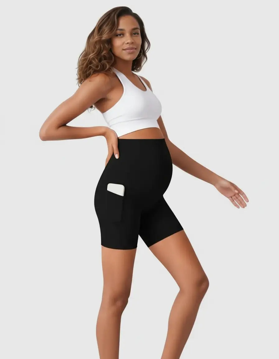 Pregnant woman in black over-belly maternity bike shorts with a phone in the side pocket.