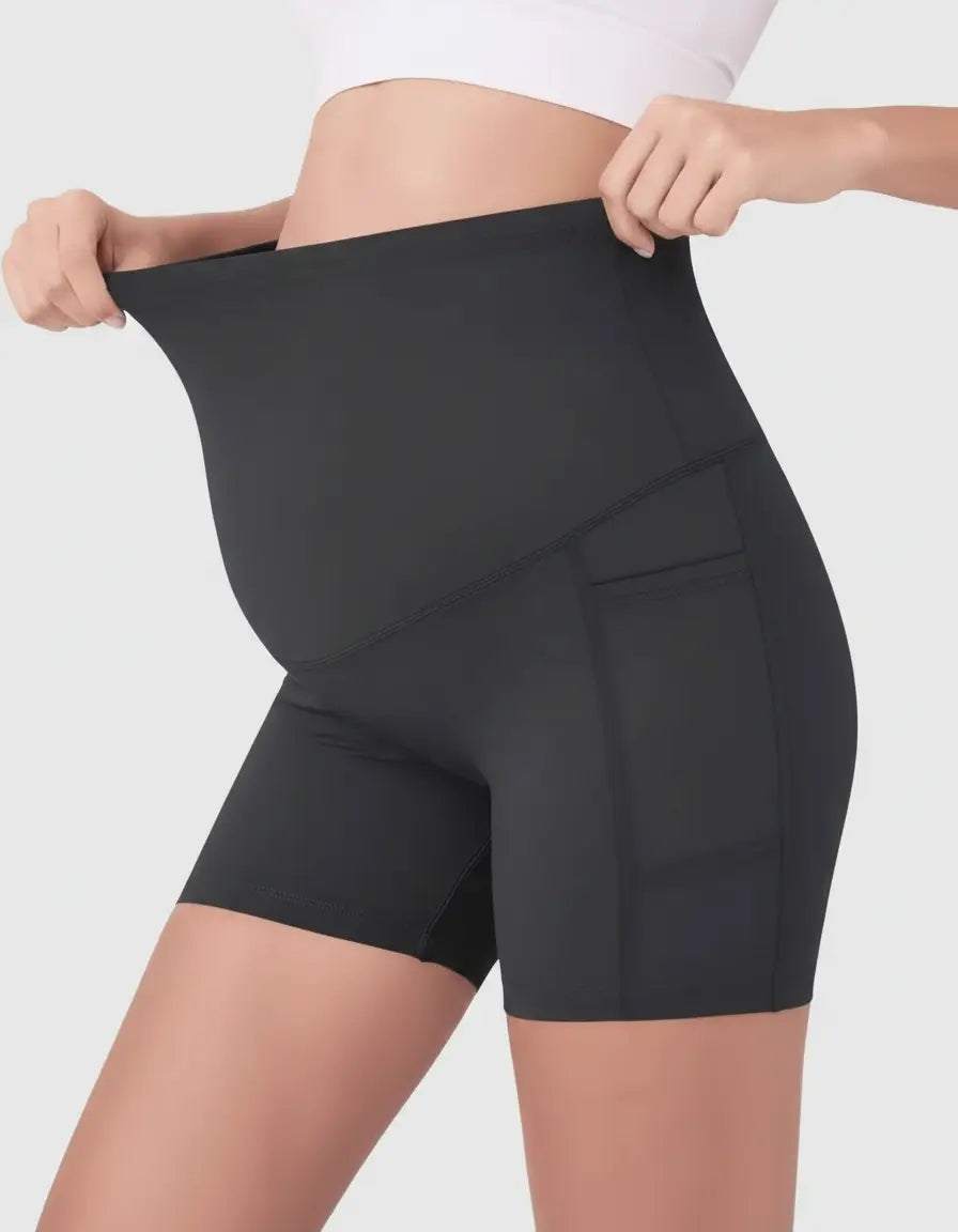 Black over-belly maternity bike shorts with side pockets, worn by a pregnant woman.