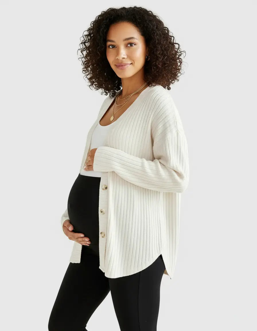 Pregnant woman in a cream ribbed button-front drop shoulder maternity top over a white tank and black leggings.