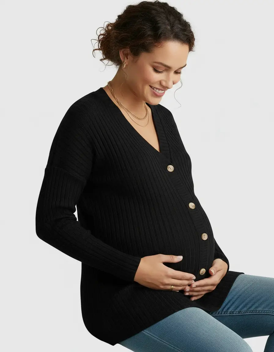 Smiling pregnant woman in a black ribbed button-front drop shoulder maternity top, holding her belly.