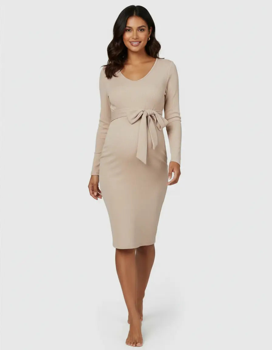 Smiling pregnant woman in a beige ribbed knit bodycon maternity midi dress with a tie-waist.