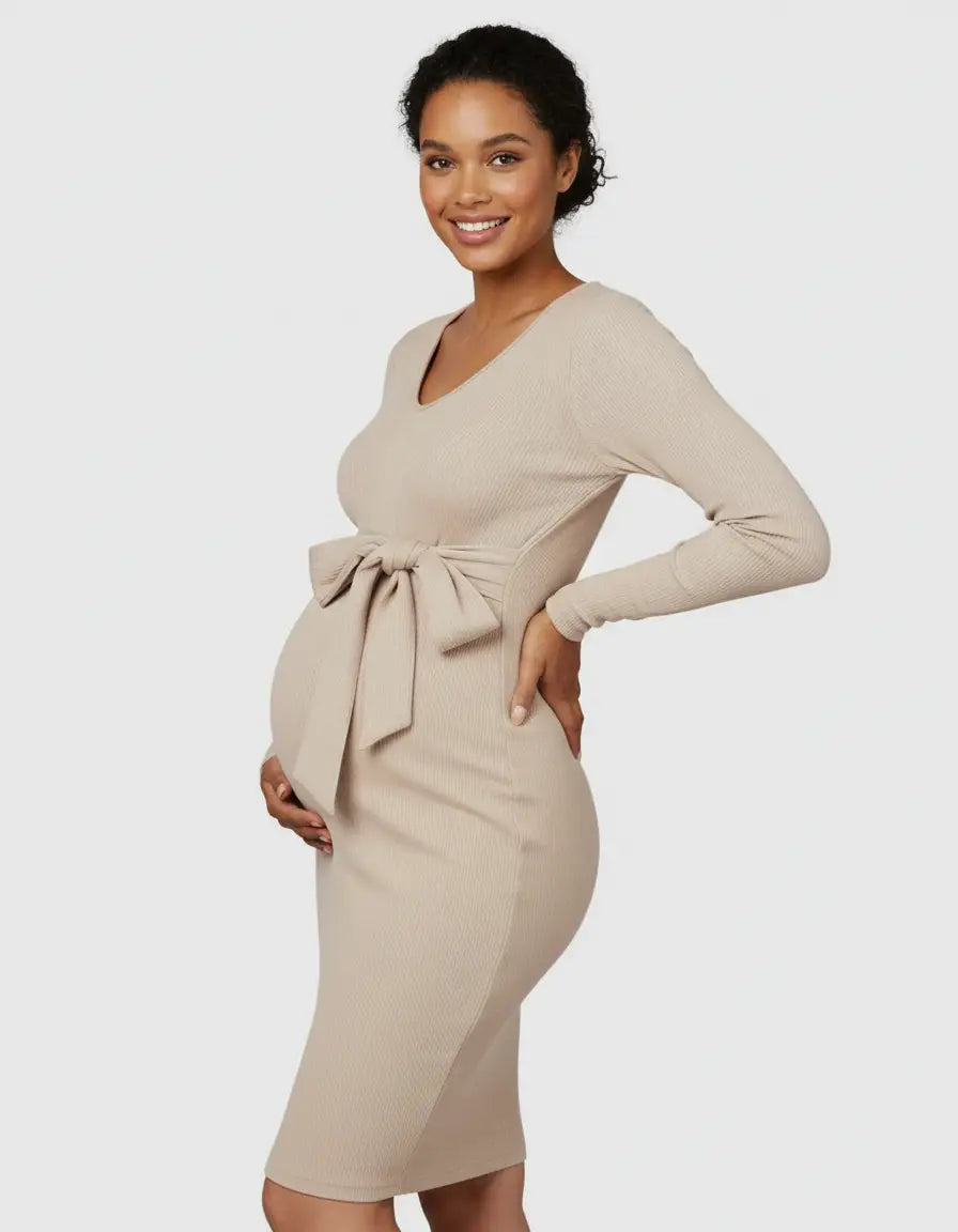 Smiling pregnant woman in a beige ribbed knit bodycon maternity midi dress with a tied waist.