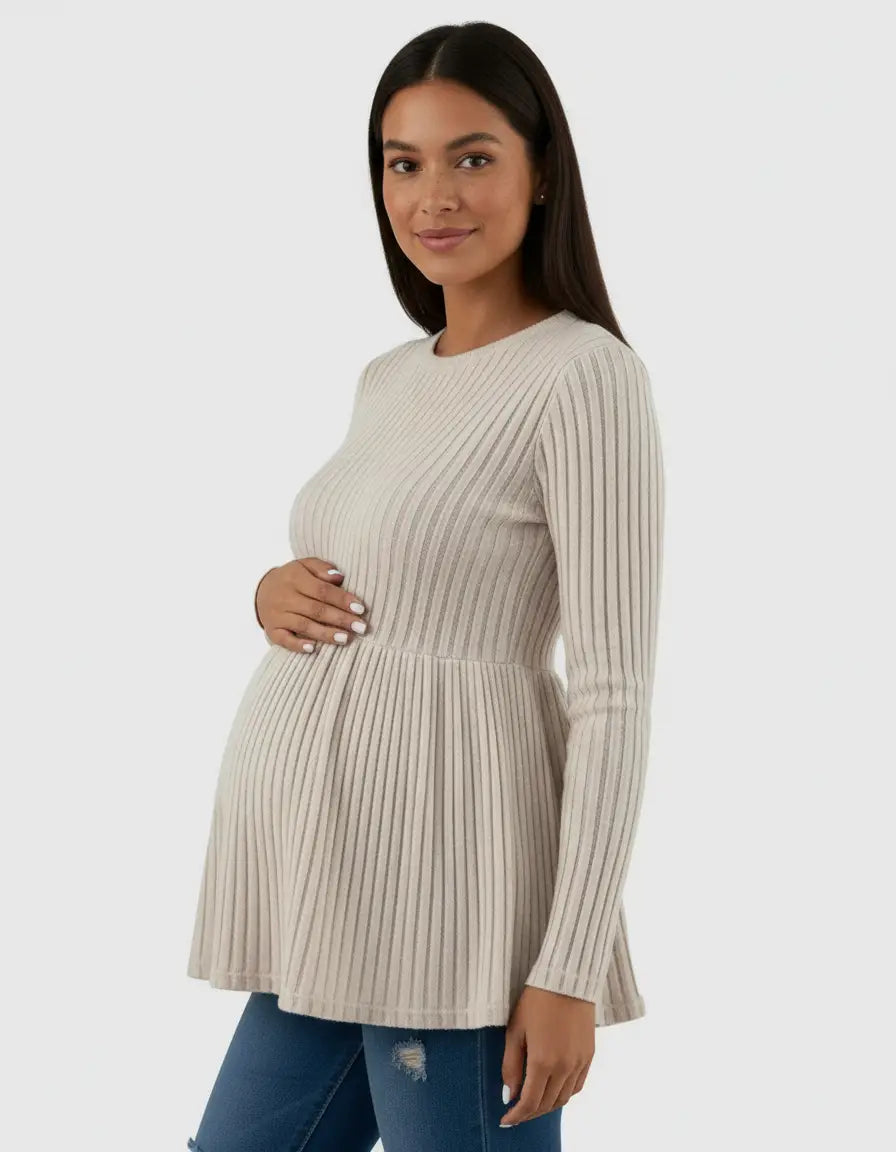 Pregnant woman in a beige ribbed knit ruffle hem maternity top with long sleeves, paired with jeans.