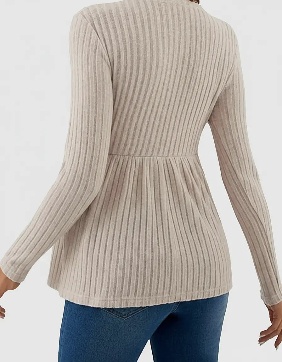 Beige ribbed knit maternity top with long sleeves and a peplum ruffle hem.