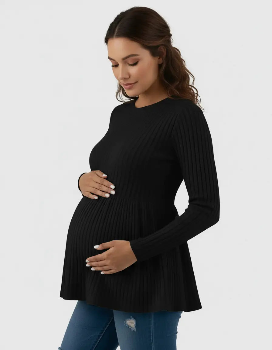 Pregnant woman in a black ribbed knit ruffle hem maternity top, gently holding her baby bump.