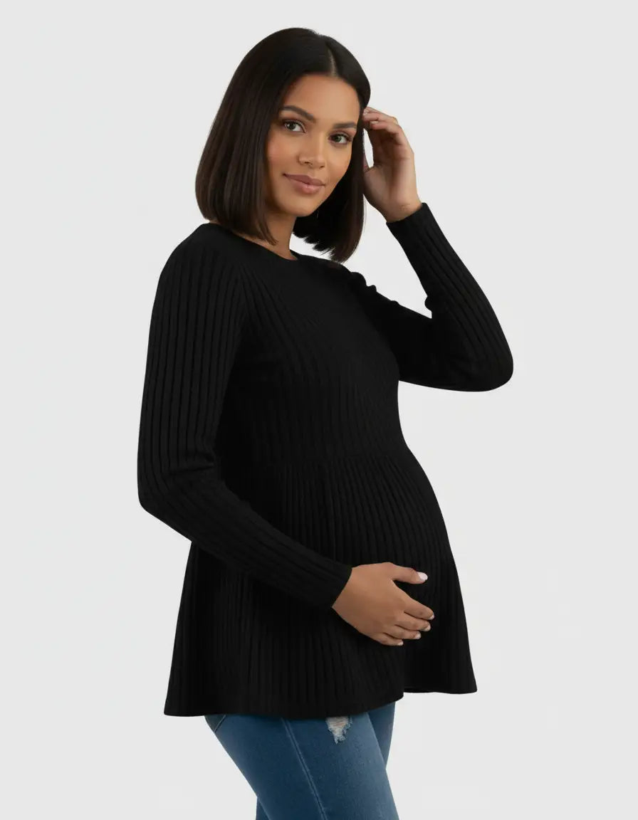 Pregnant woman in a black ribbed knit ruffle hem maternity top, holding her baby bump.