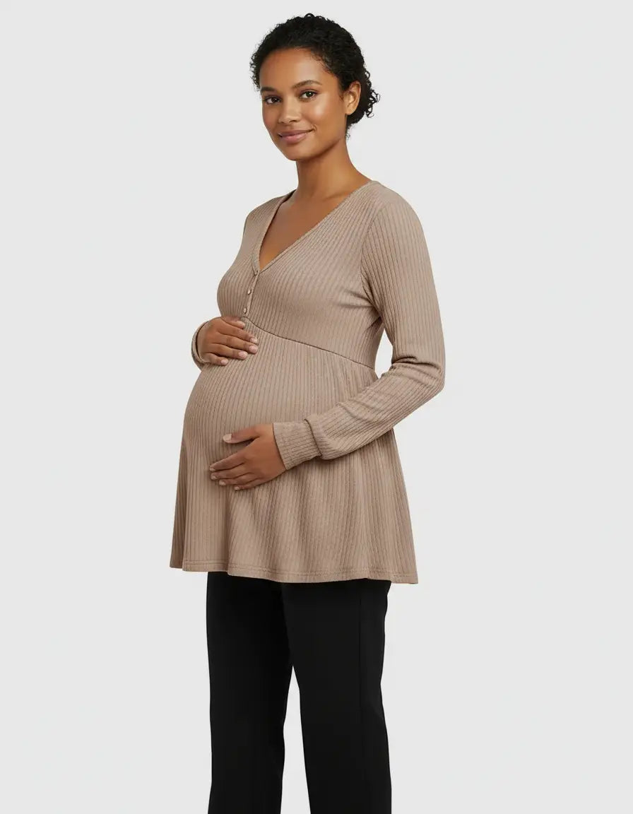 Smiling pregnant woman in a beige ribbed V-neck maternity top with long sleeves and a peplum hem.
