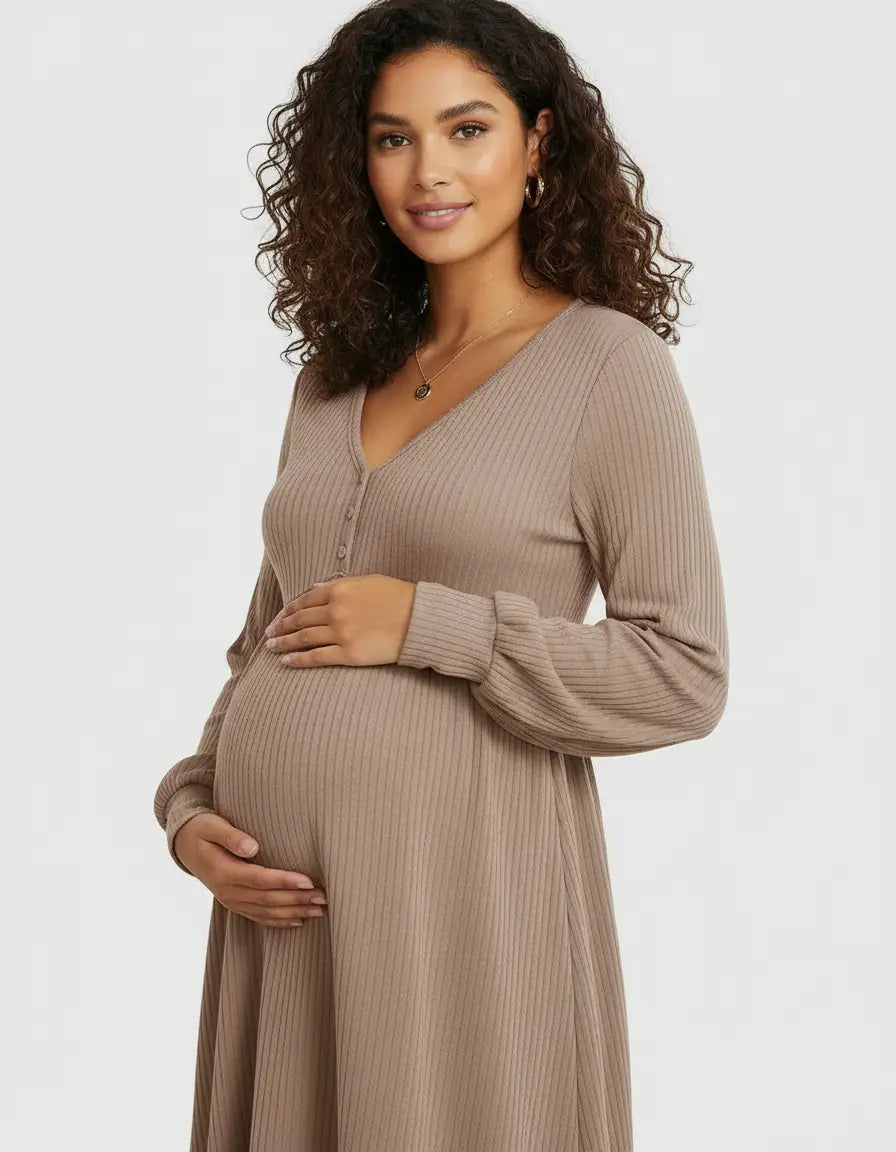 Pregnant woman in a brown ribbed V-neck maternity top with long sleeves, holding her belly.