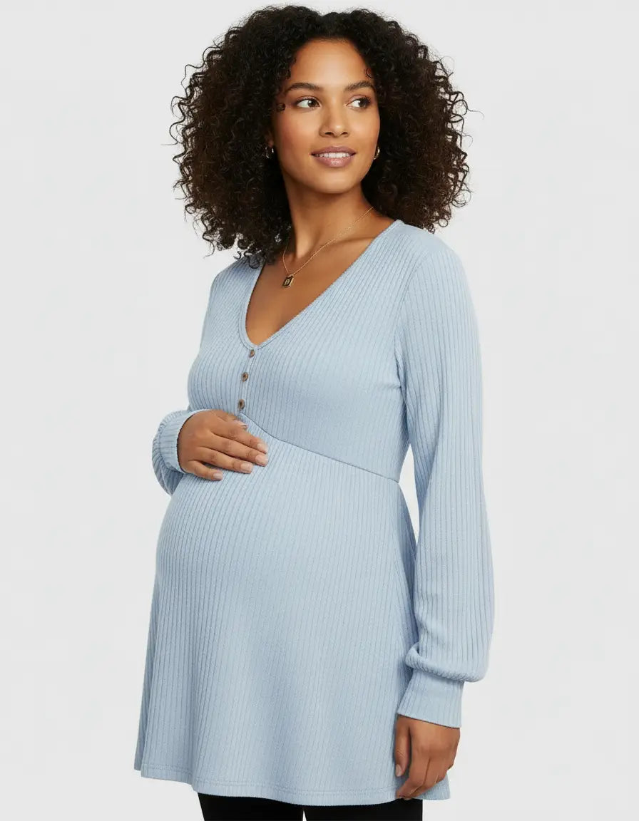 Pregnant woman in a light blue ribbed V-neck maternity top with long sleeves and button details.