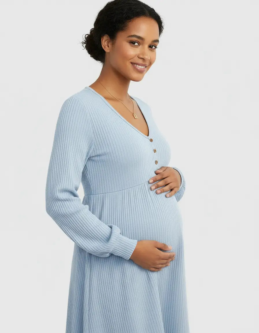 Smiling pregnant woman in a light blue ribbed V-neck maternity top with button details.