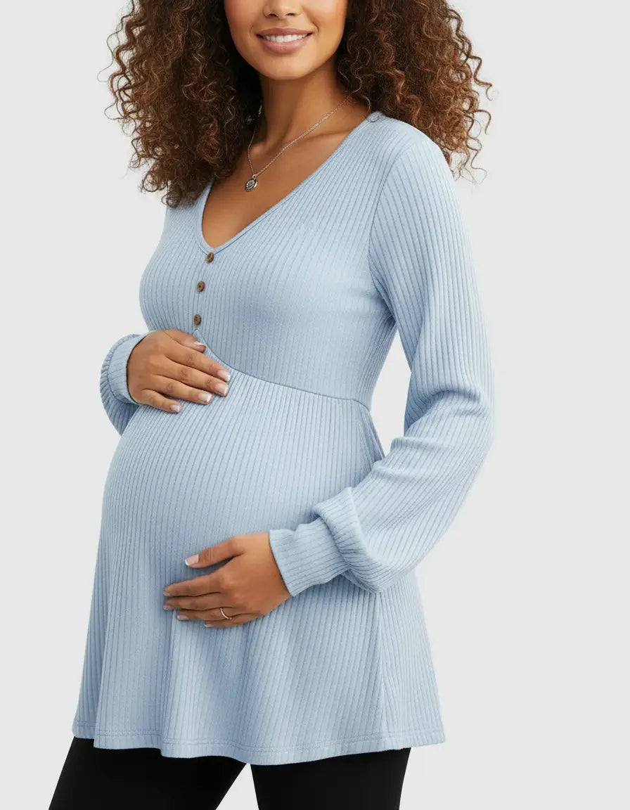 Pregnant woman in a light blue ribbed V-neck maternity top with long sleeves and button details.