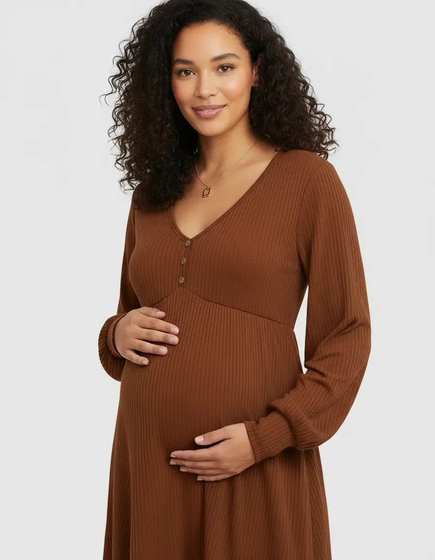 Pregnant woman in a brown ribbed V-neck maternity top with button details, holding her belly.