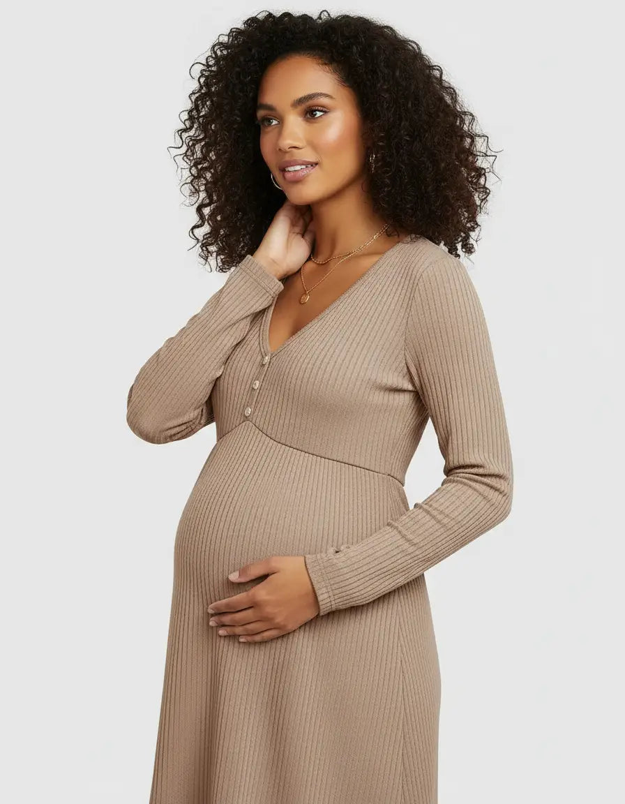 Pregnant woman in a beige ribbed V-neck maternity top with long sleeves, holding her belly.