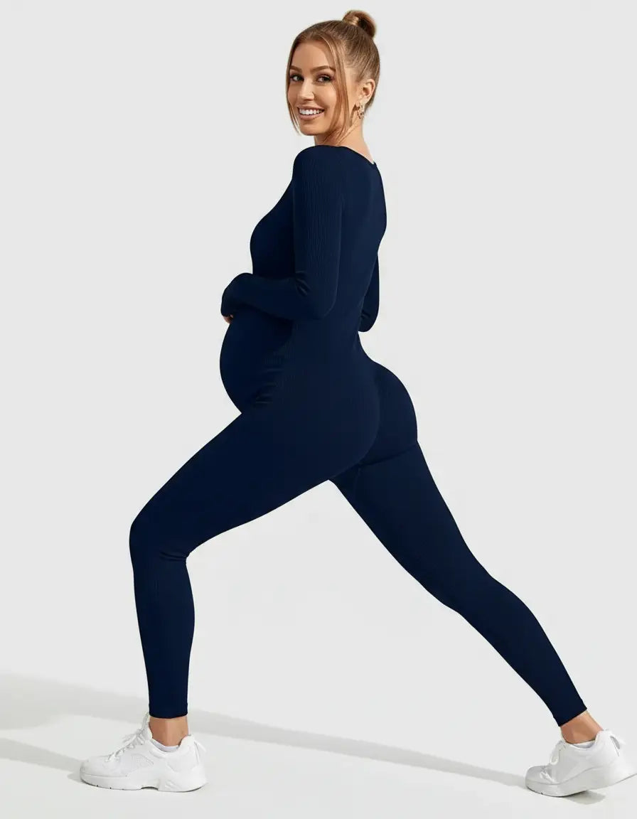 Smiling pregnant woman in a navy seamless ribbed long-sleeve ankle-length maternity bodysuit.