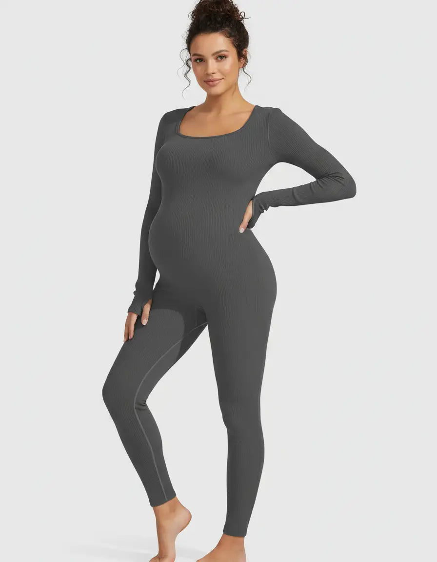 Pregnant woman in a charcoal ribbed seamless ankle-length maternity bodysuit with a square neckline.