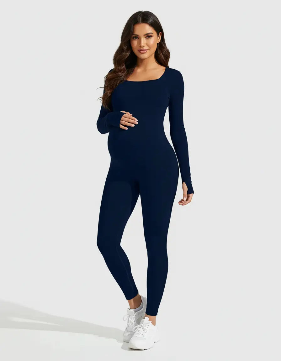 Pregnant woman in a navy seamless ankle-length maternity bodysuit with long sleeves and thumbholes.