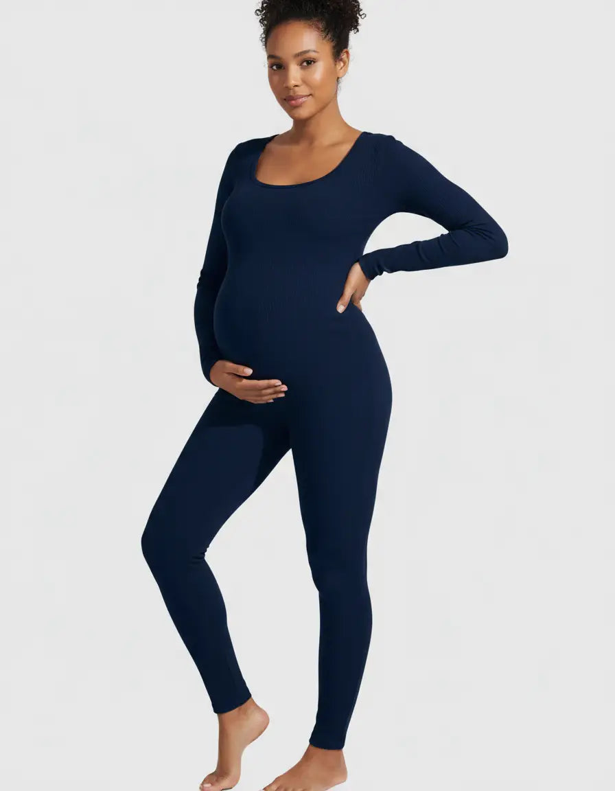 Smiling pregnant woman in a navy seamless ankle-length maternity bodysuit with a scoop neck.