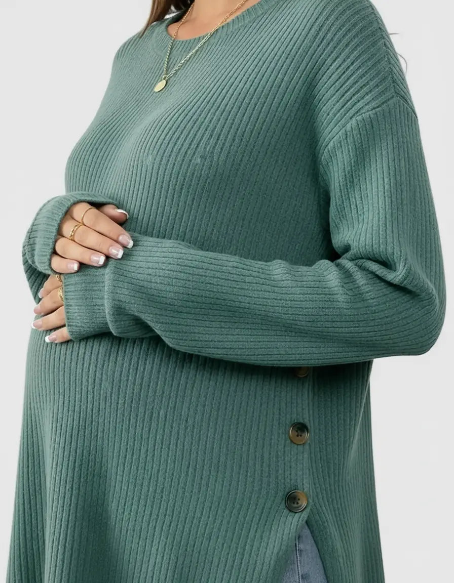 Pregnant woman wearing a soft-knit, relaxed-fit sage green maternity sweatshirt with side buttons.