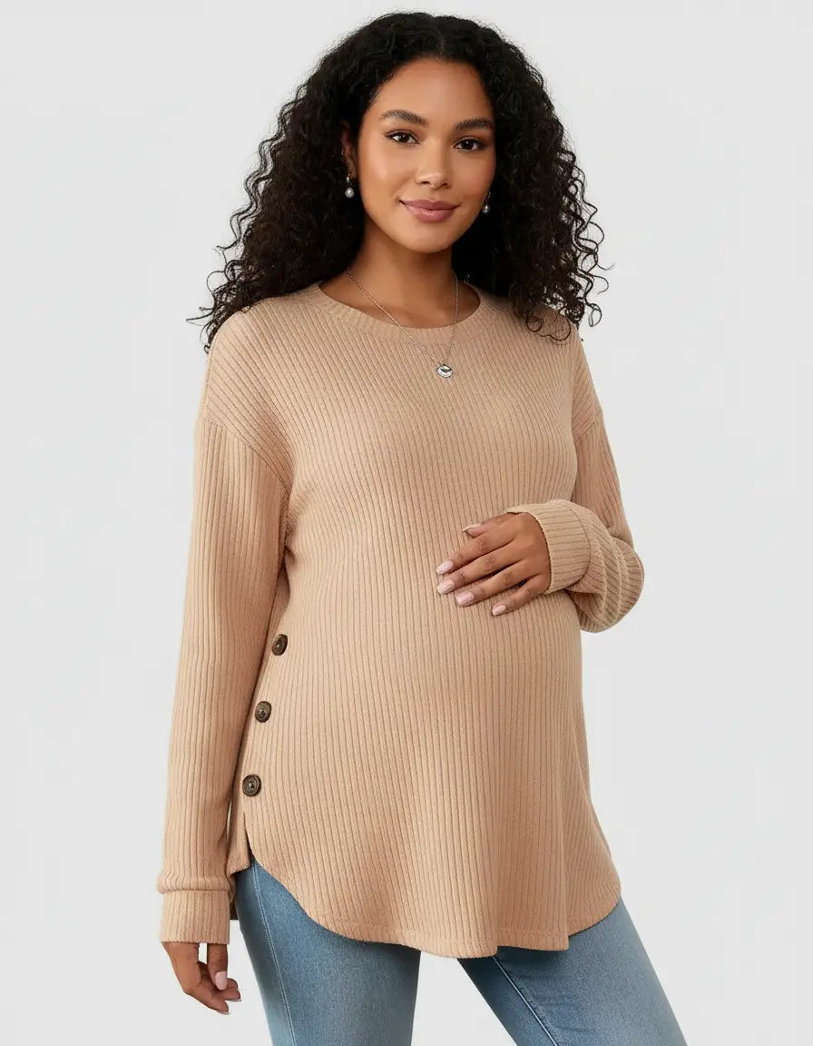 Pregnant woman in a beige soft-knit relaxed-fit maternity sweatshirt with side buttons and a curved hem.