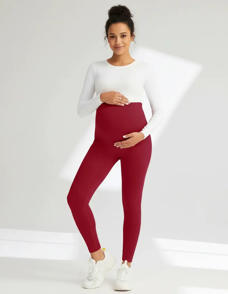 Pregnant woman in full-length, soft-stretch burgundy maternity leggings with a supportive high waist.