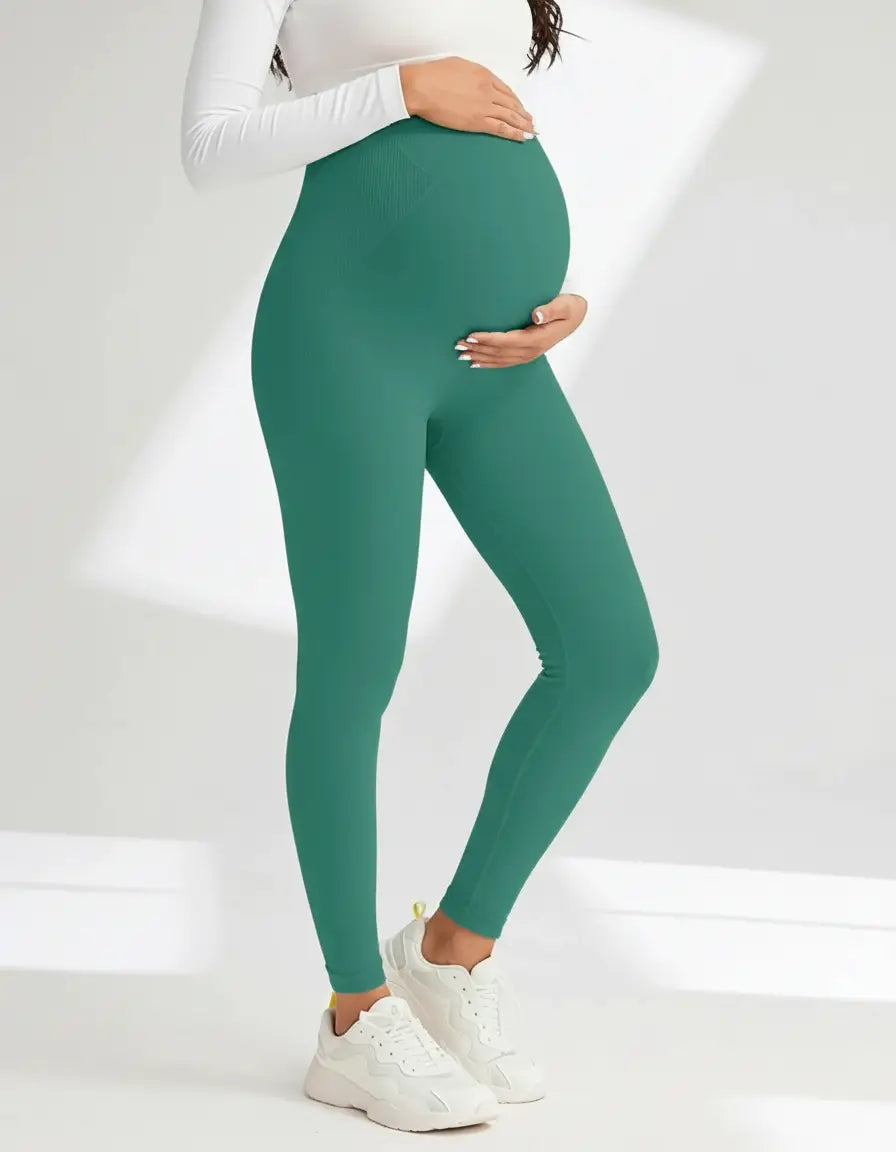 Pregnant woman in soft-stretch, full-length teal maternity leggings with a high, supportive waistband.