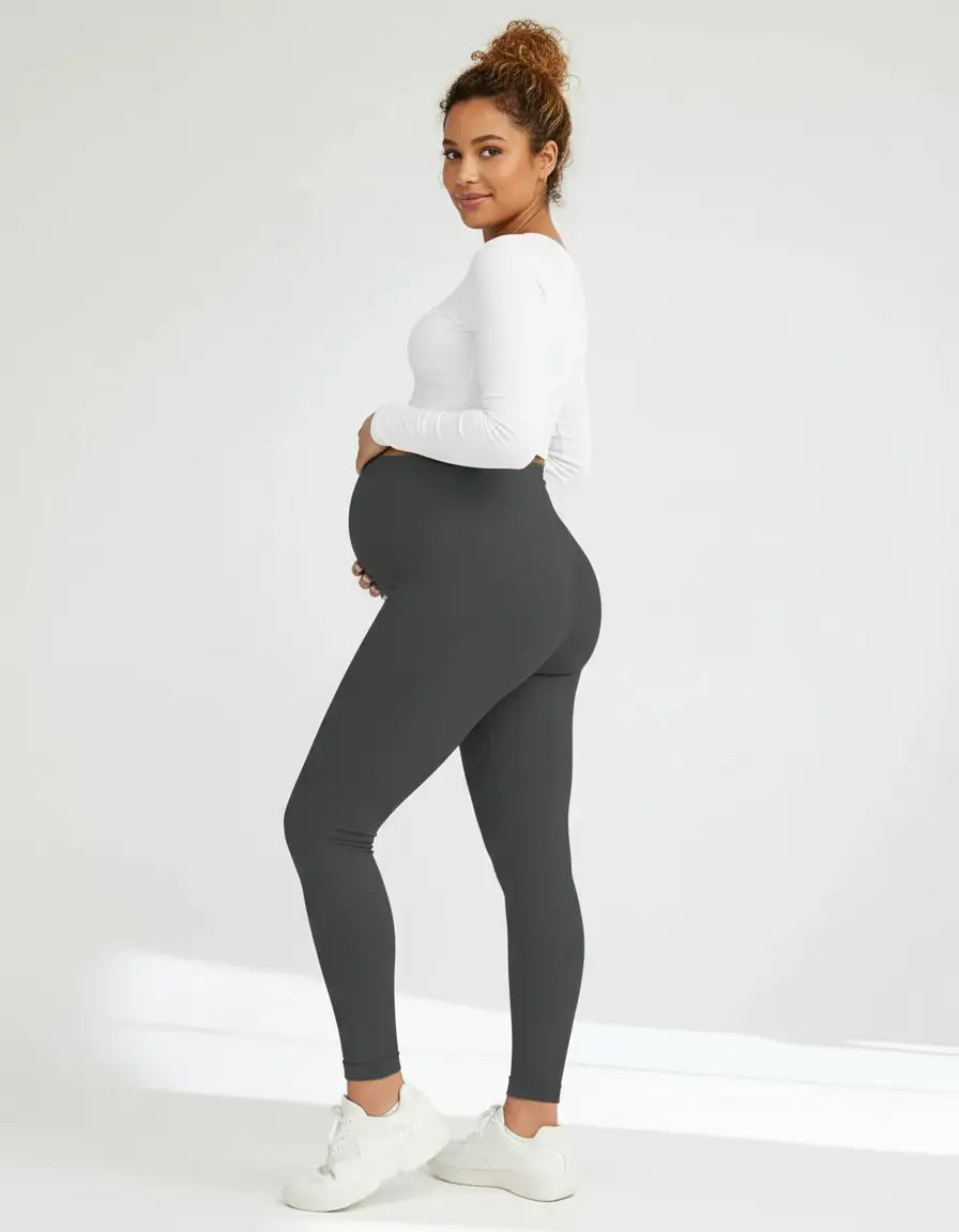 Pregnant woman in dark gray soft-stretch full-length maternity leggings with an over-the-bump design.