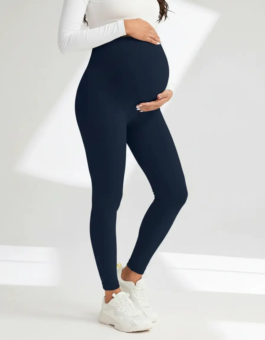 Pregnant woman in soft-stretch navy blue full-length maternity leggings with an over-the-bump design.