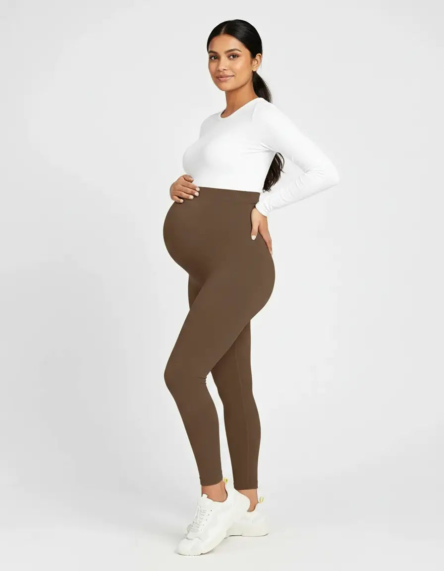 Pregnant woman in soft-stretch, full-length brown maternity leggings with a high, supportive waistband.