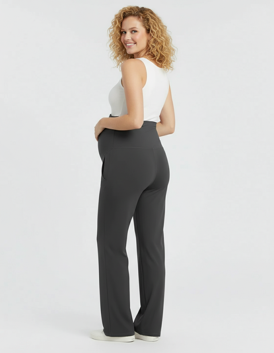 Smiling pregnant woman in dark gray high-rise wide-leg maternity pants with belly support panel.
