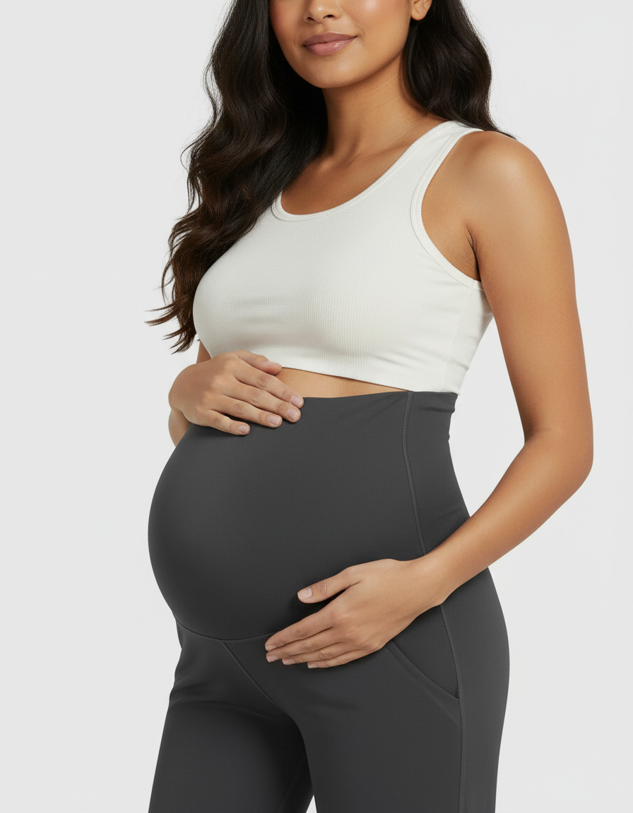 Maternity model in dark gray high-rise wide-leg pants with belly support panel and white ribbed tank top.
