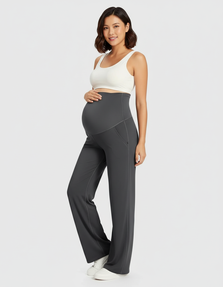 Smiling pregnant woman in dark gray soft stretch high-rise wide-leg maternity pants with belly support.