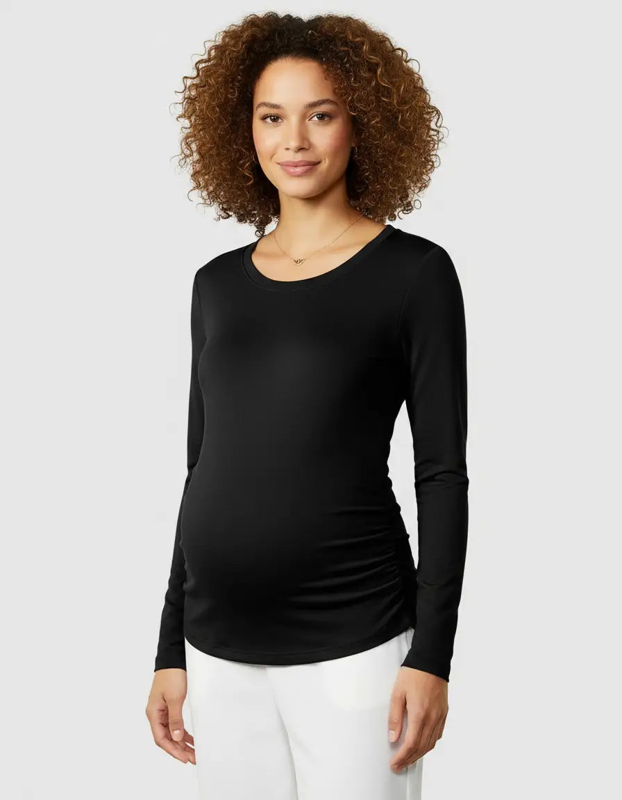 Smiling pregnant woman in a black long-sleeve thermal maternity top with side ruching.