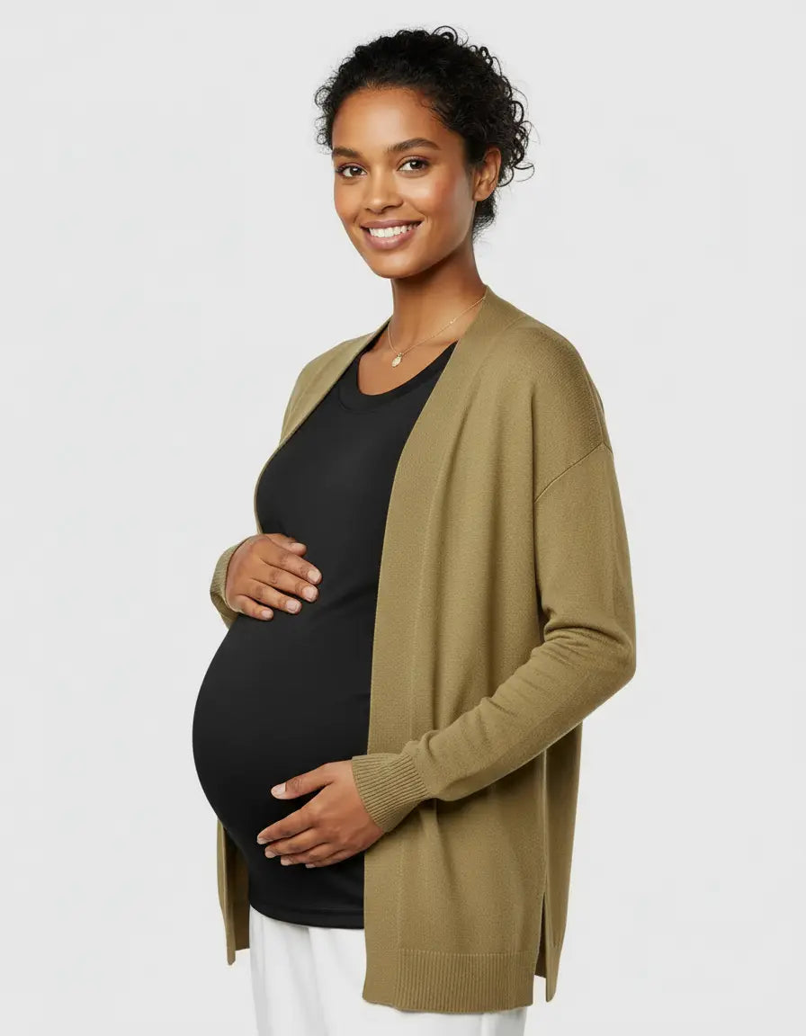 Smiling pregnant woman in a black thermal long sleeve maternity top and olive green cardigan.