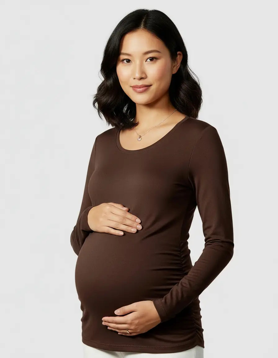 Pregnant woman in a brown, soft thermal long-sleeve maternity top with ruched sides.