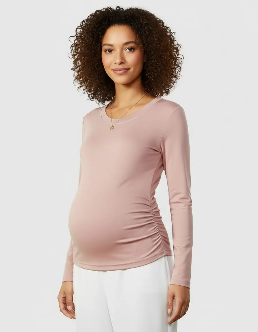 Smiling pregnant woman in a pink thermal long-sleeve maternity top with side ruching.