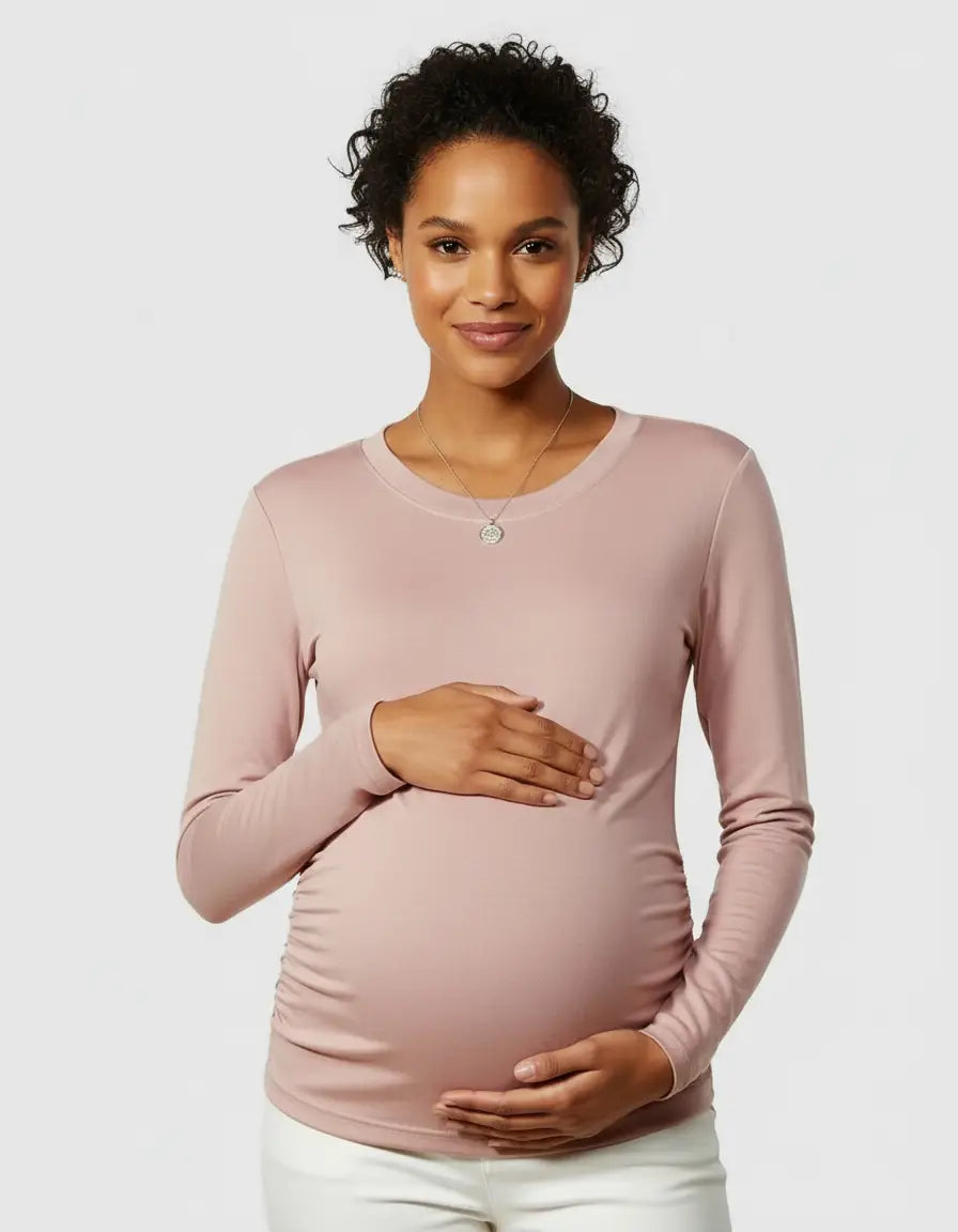 Smiling pregnant woman in a soft pink thermal long sleeve maternity top with ruched sides.