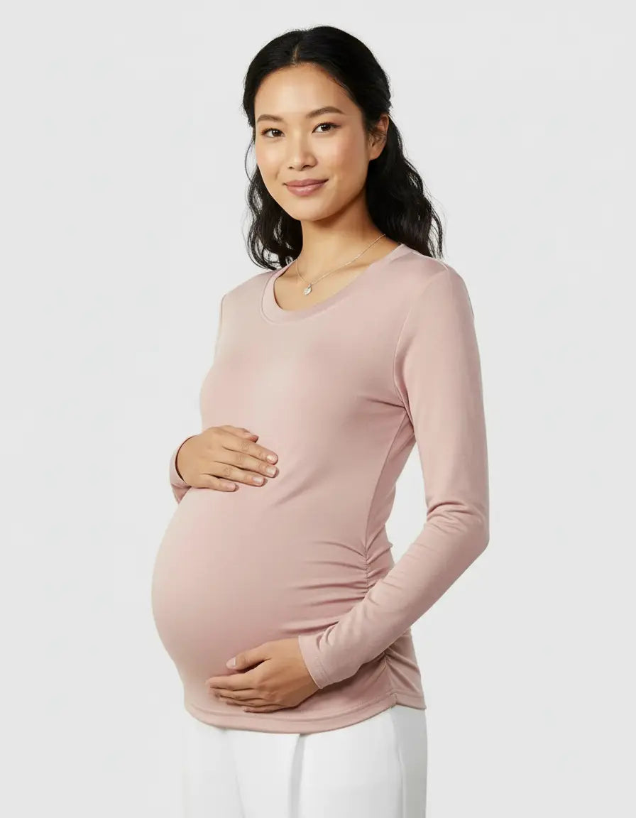 Pregnant woman in a blush pink thermal long sleeve maternity top with side ruching.