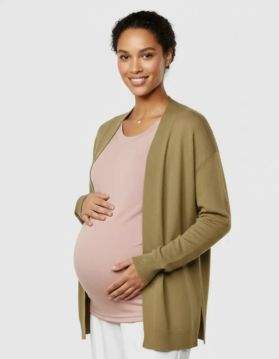 Smiling pregnant woman in a pink thermal long sleeve maternity top and olive green cardigan.