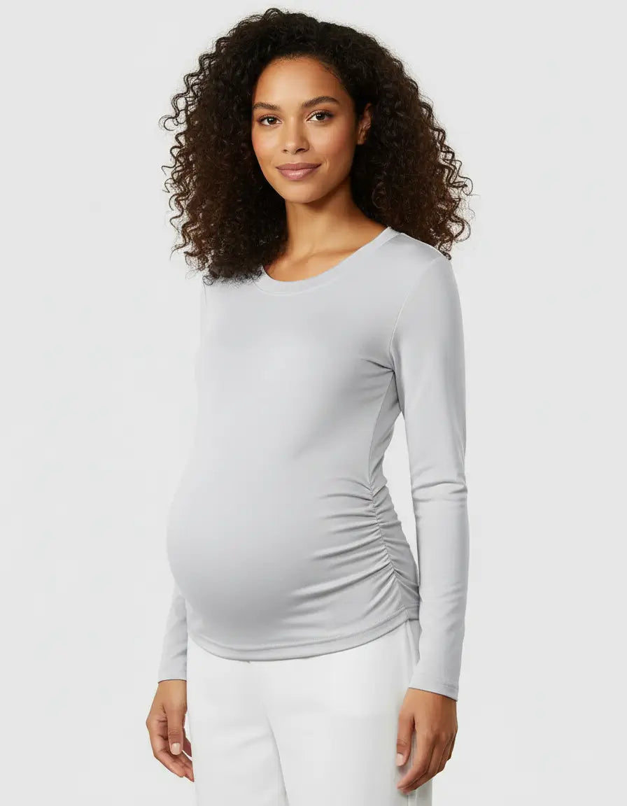 Smiling pregnant woman in a light gray thermal long-sleeve maternity top with side ruching.