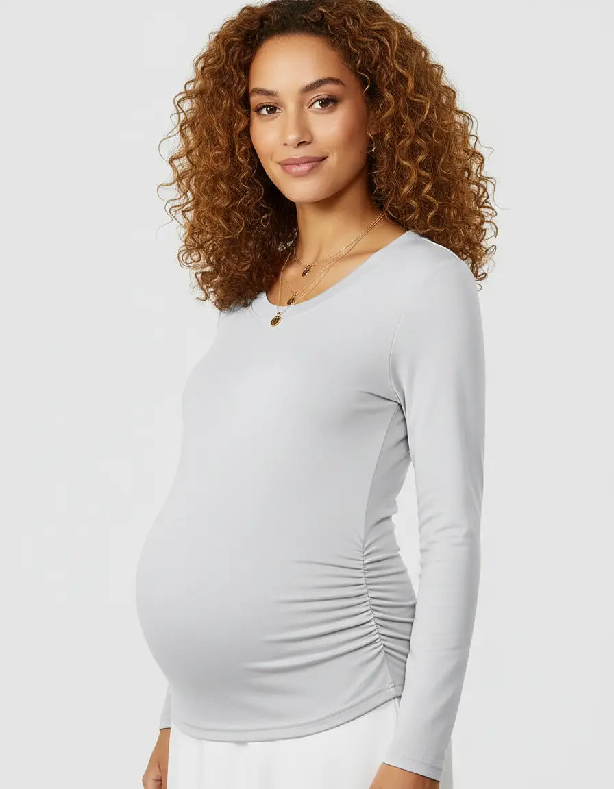 Smiling pregnant woman in a light grey thermal long-sleeve maternity top with side ruching.