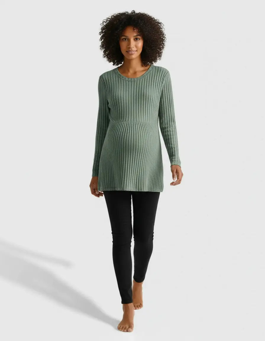 Woman in a sage green stretch-ribbed maternity top with a casual fit, paired with black leggings.