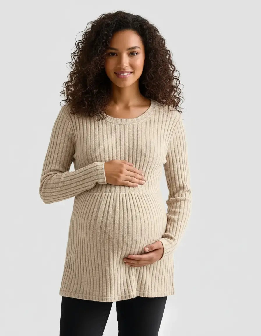 Smiling pregnant woman in a beige stretch-ribbed casual-fit maternity top, hands on belly.