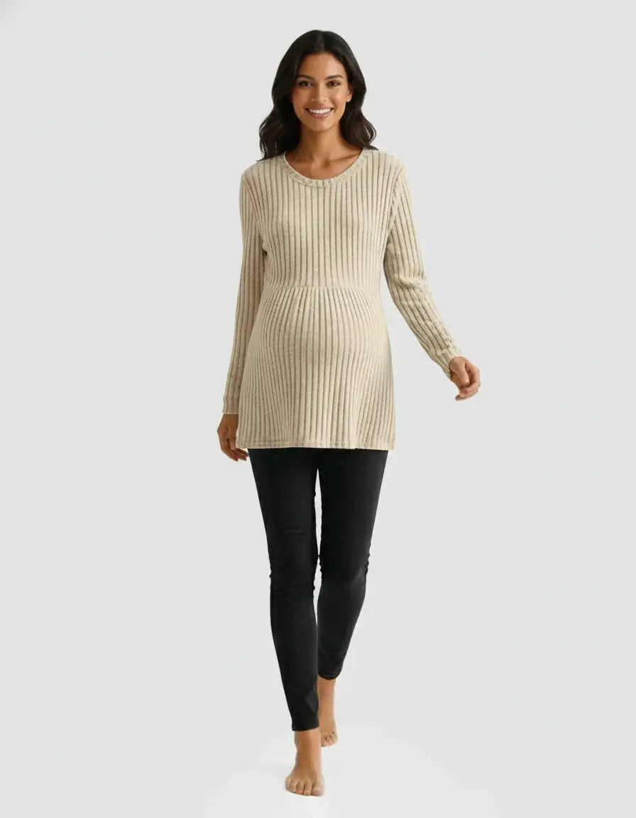 Smiling pregnant woman in a beige stretch-ribbed casual-fit maternity top and black pants.